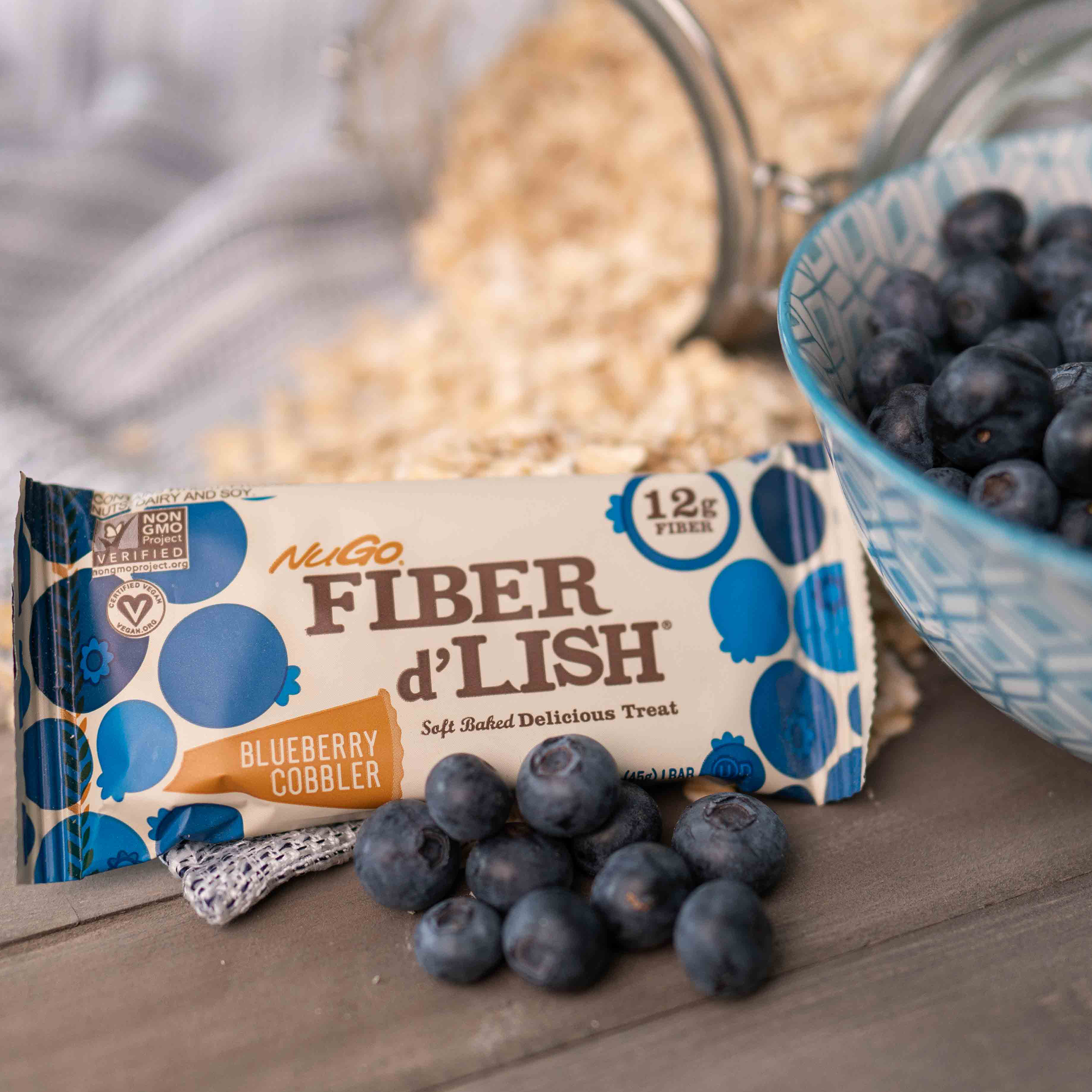 NuGo Fiber Blueberry Cobbler with Blueberries and spilled oats in the background