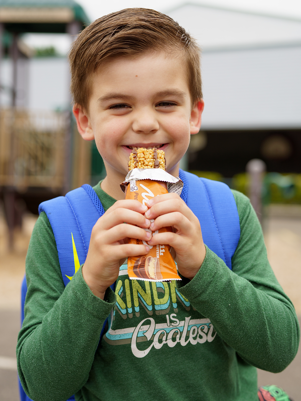 Little boy eating a NuGo Original Peanut Butter Chocolate Bar