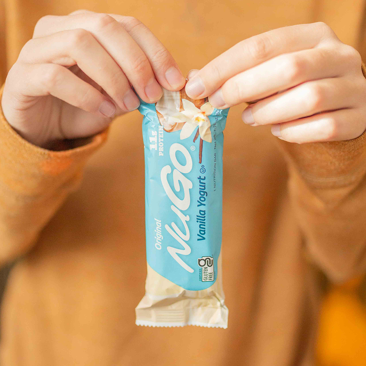 Woman's hands opening NuGo Original Vanilla Yogurt