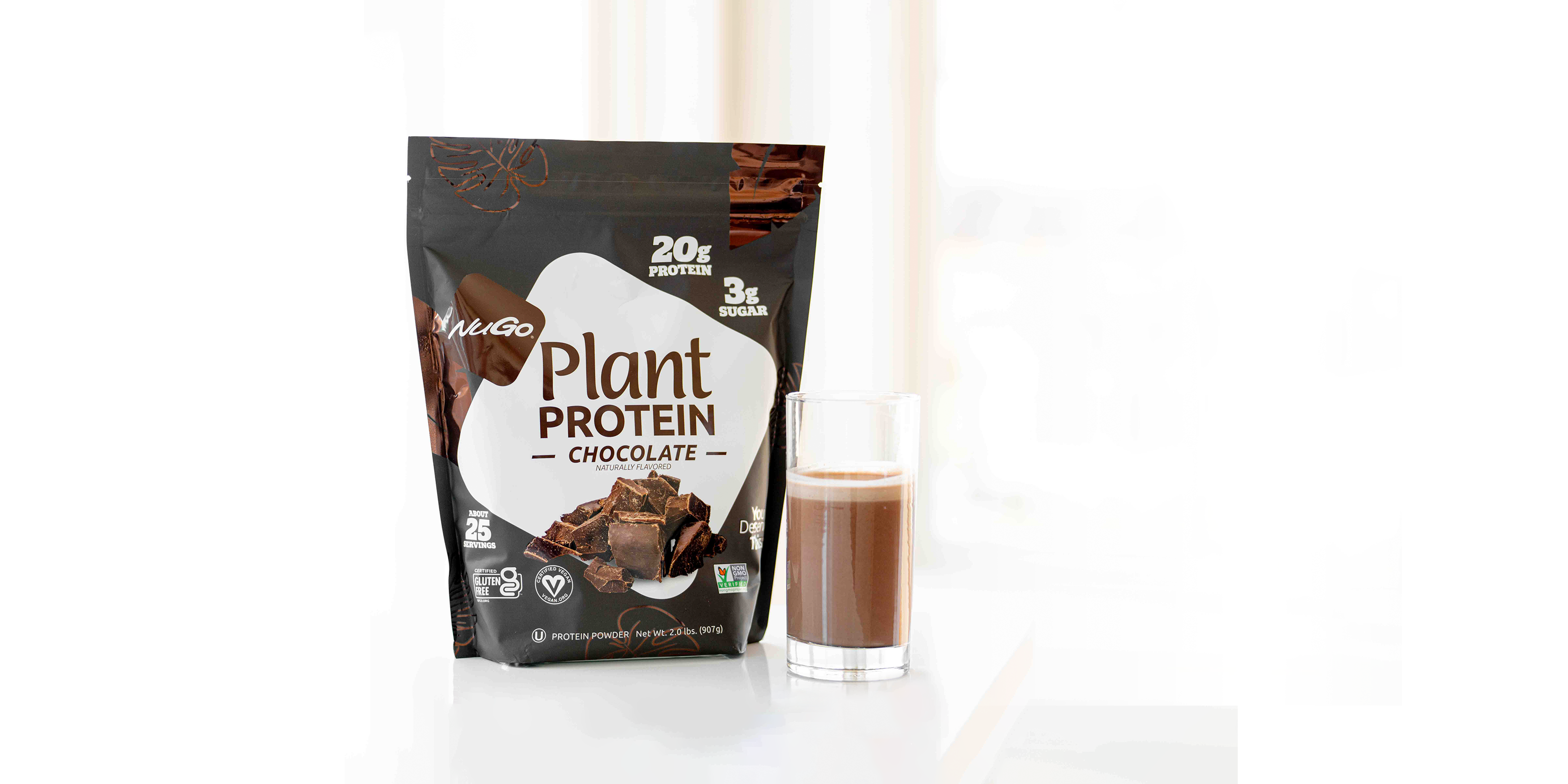 NuGo Protien Powder Chocolate next to tall glass with product inside