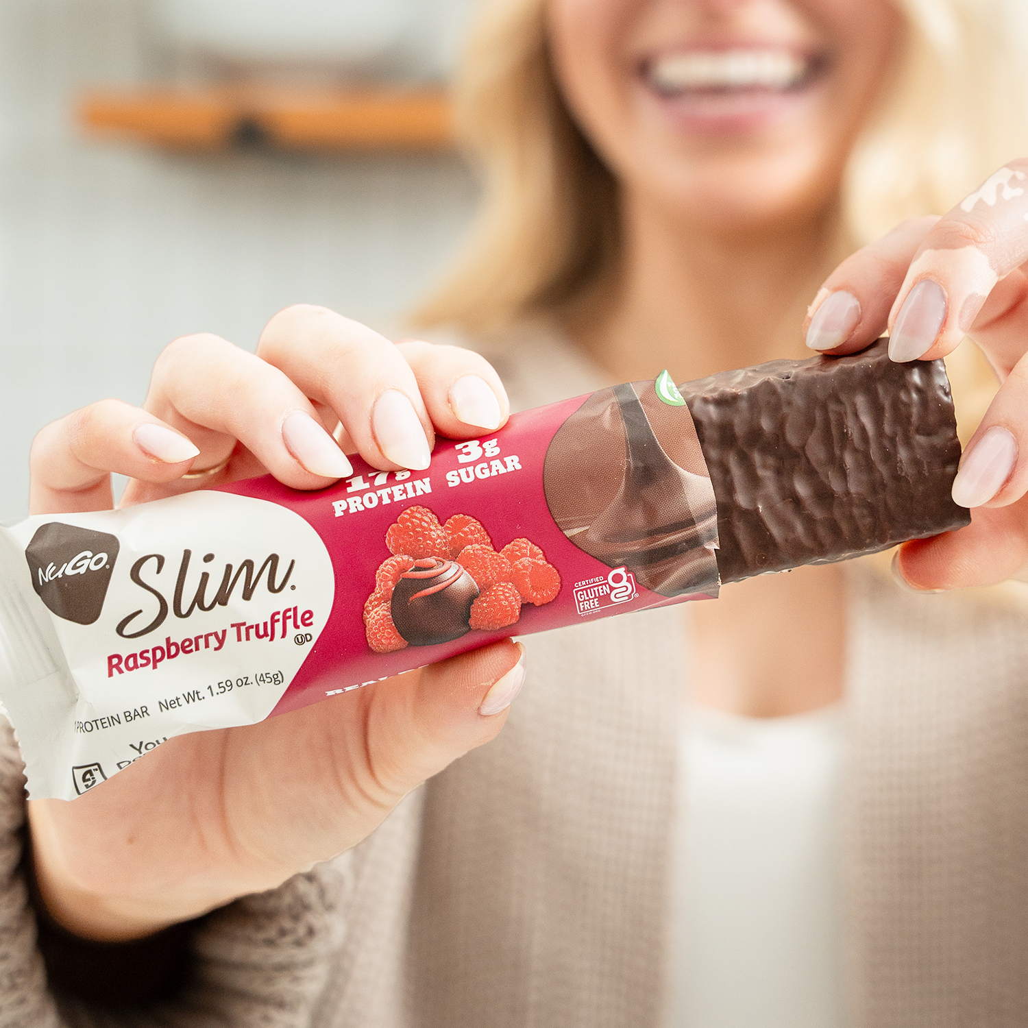 Person holding a NuGo Slim Raspberry Truffle protein bar
