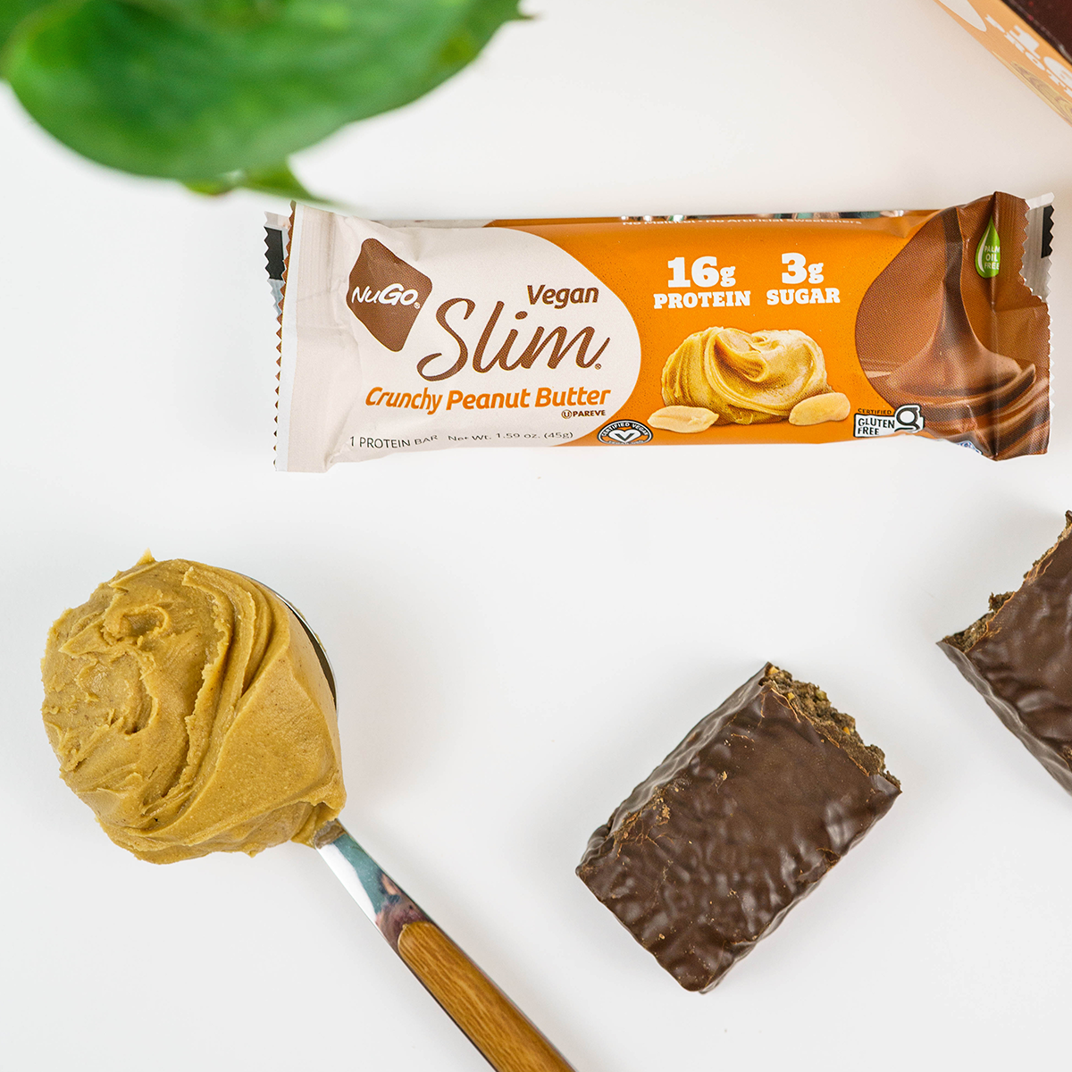 NuGo Slim Crunchy Peanut Butter next to spoon of peanut butter