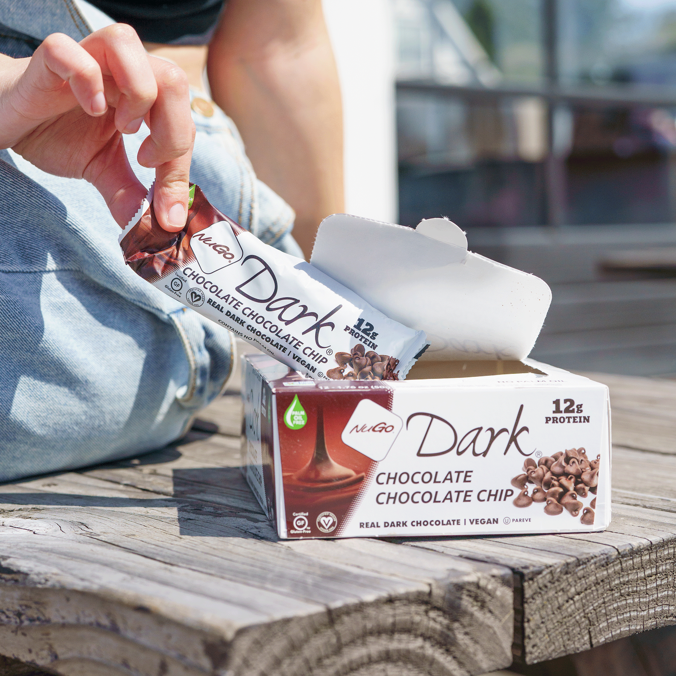 Woman on bench pulling Chocolate Chip Bar from Box