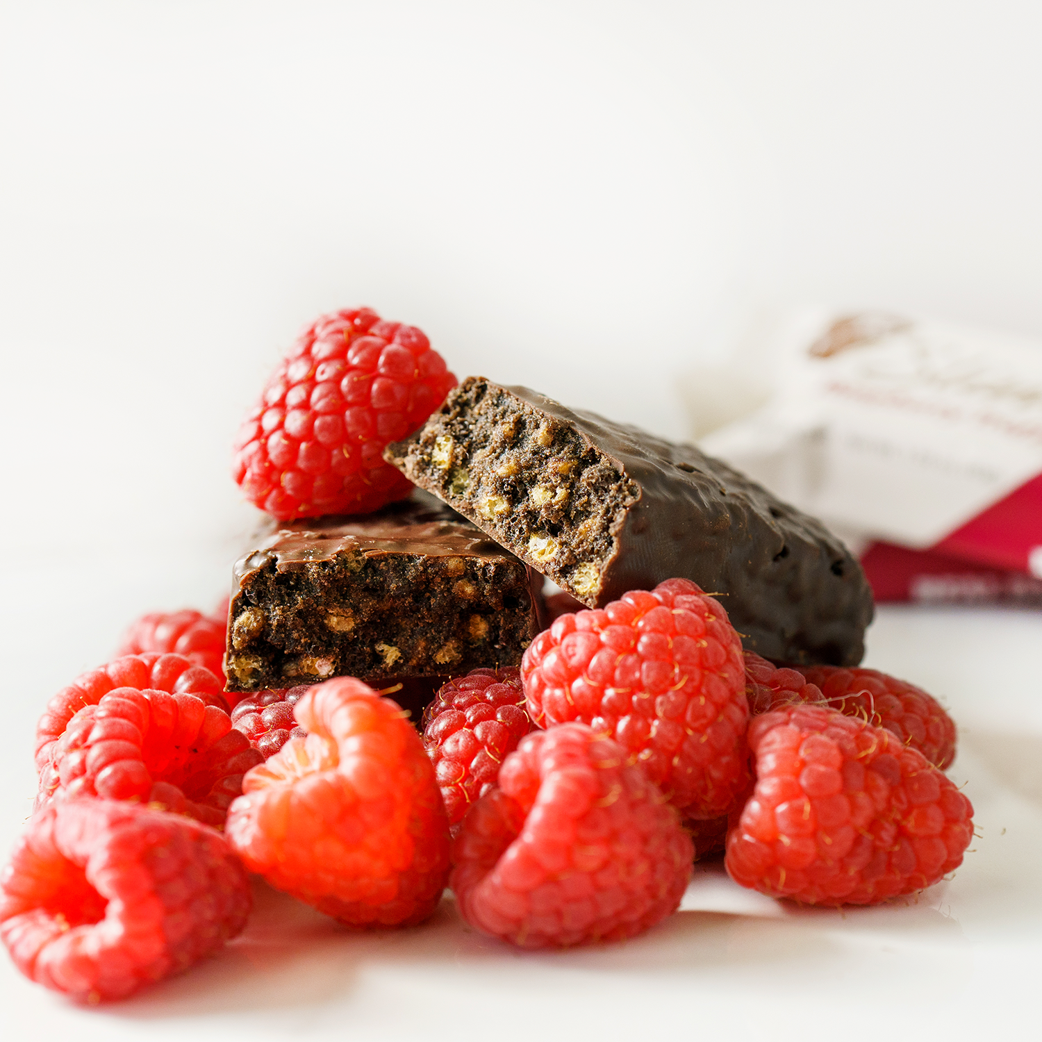 NuGo Slim Rasperry Truffle bar on top of a pile of Raspberries