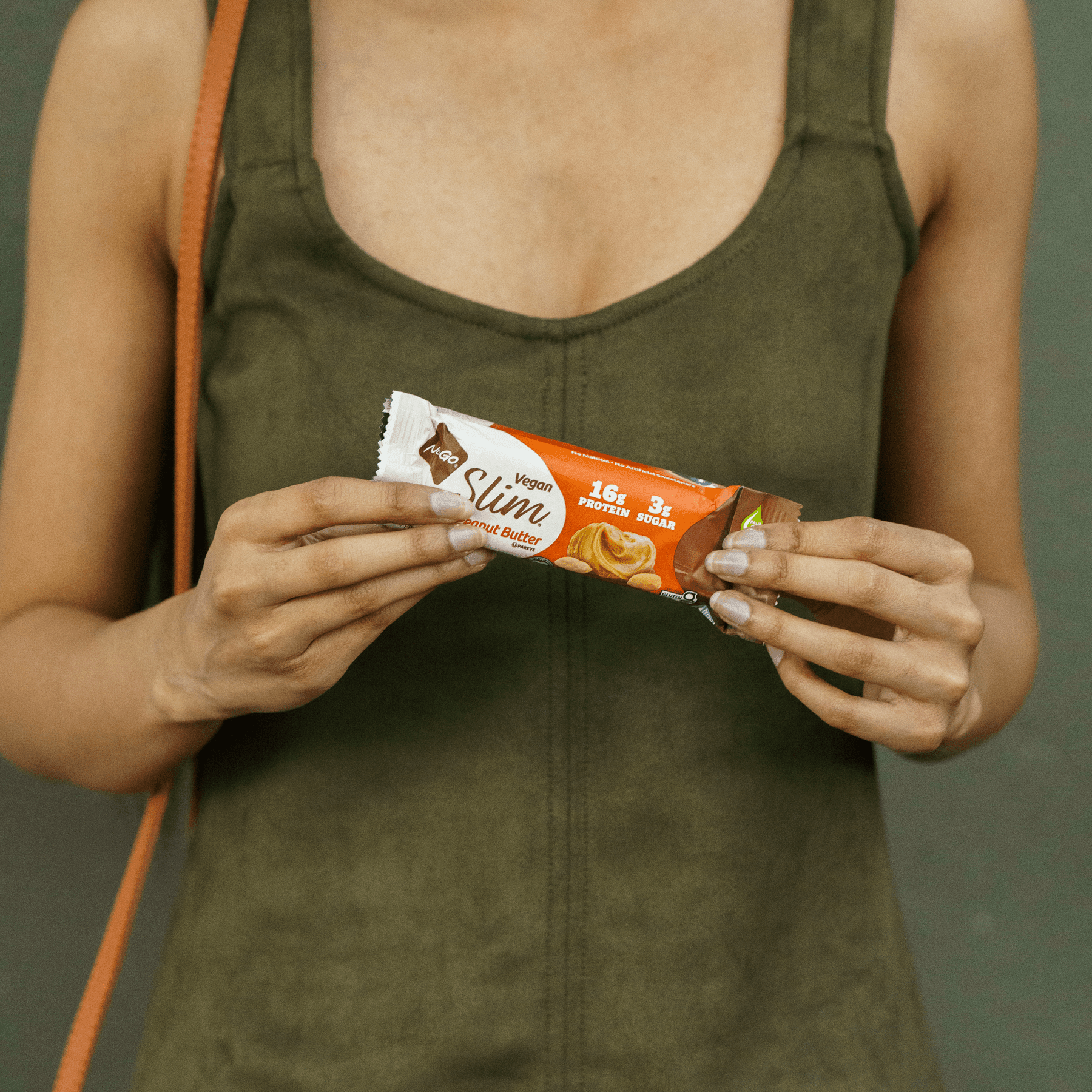 Woman holding NuGo Slim Crunchy Peanut Butter Bar