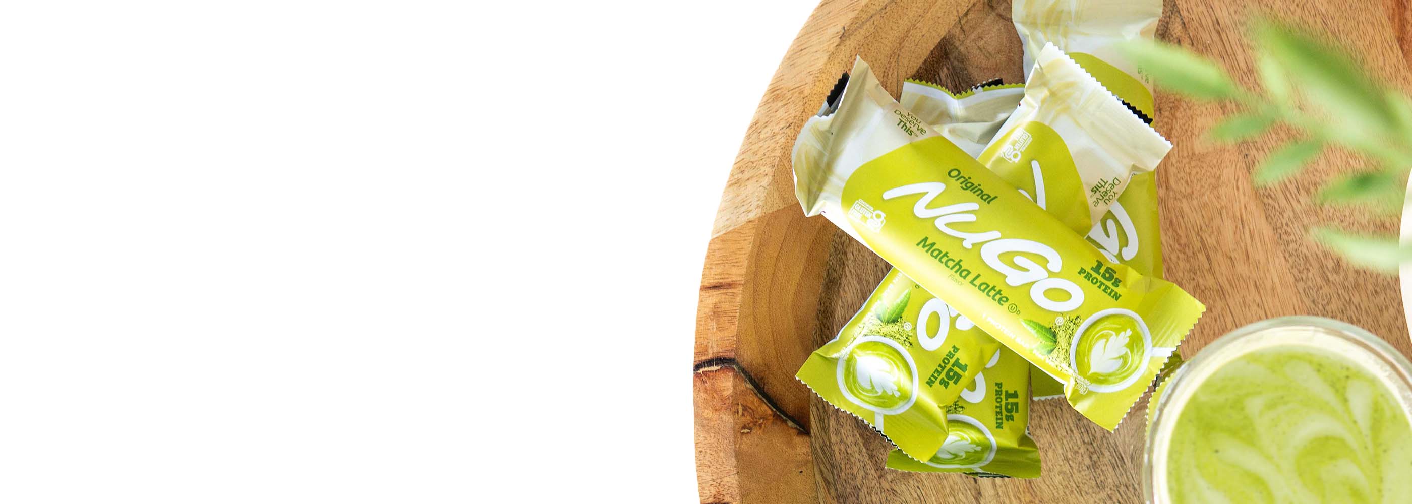 Matcha Latte Original bars stacked on top of each other with a cup of matcha tea.