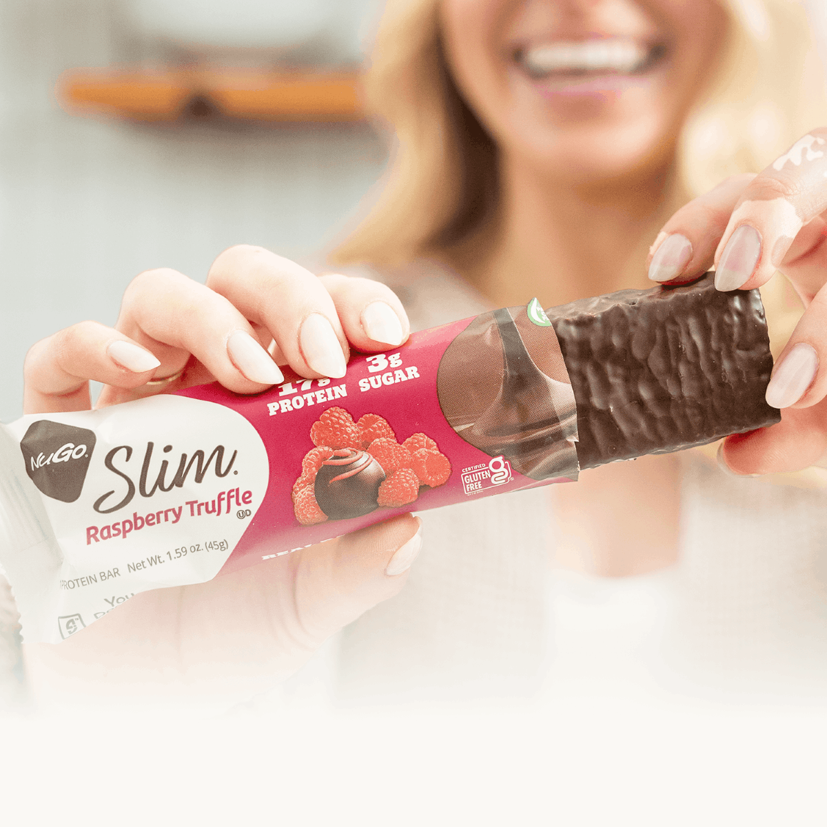 NuGo Slim Raspberry Truffle Bar in  Woman's Hand
